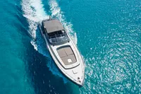 Mangusta 80 Open yacht cruising on clear blue water, aerial view, 2004 model.
