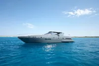 2004 Mangusta 80 Open yacht cruising on clear blue waters under a sunny sky.