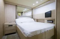 Luxurious bedroom interior of 2004 Mangusta 80 Open yacht with modern amenities.