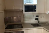 Compact kitchen in a 2004 Mangusta 80 Open yacht with modern appliances.