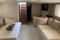 Luxurious interior of 2004 Mangusta 80 Open yacht with beige seating and wooden accents.
