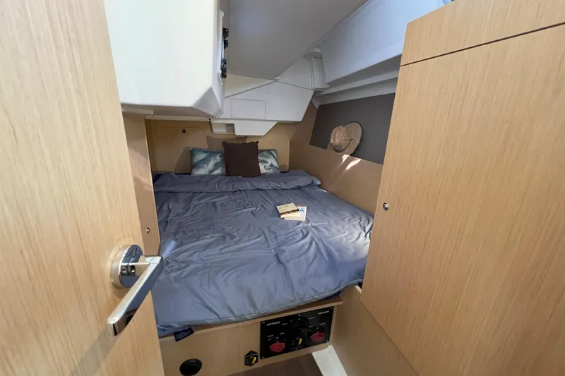 Grand Cru Yacht Photos Pics Cozy cabin interior of 2018 Beneteau Oceanis 38.1 sailboat with bed and wooden finish.