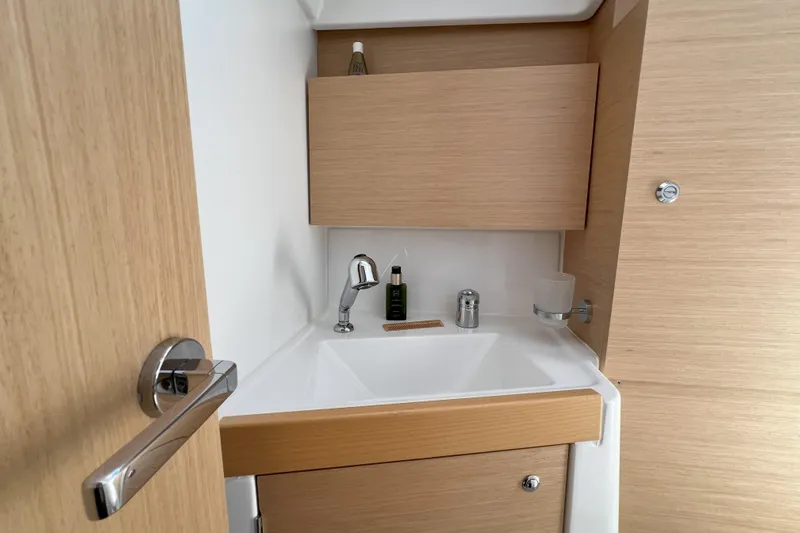 Grand Cru Yacht Photos Pics Modern bathroom sink on 2018 Beneteau Oceanis 38.1 yacht, featuring sleek wood cabinetry.