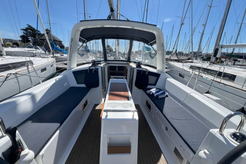 Grand Cru Yacht Photos Pics 2018 Beneteau Oceanis 38.1 sailboat interior with seating and helm, docked in marina.