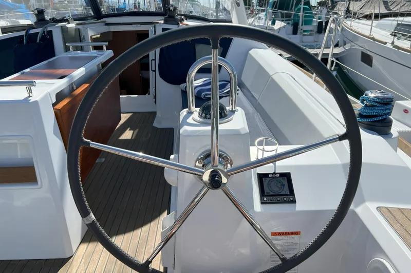 Grand Cru Yacht Photos Pics Steering wheel of a 2018 Beneteau Oceanis 38.1 sailboat, featuring modern navigation equipment.