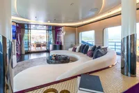 Luxurious yacht interior with curved sofa, modern decor, and ocean view, Bilgin Custom 2023 model.