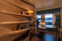 Luxurious yacht interior with modern desk, curved shelves, and ocean view. Bilgin Custom 2023 model.