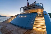 Luxurious 2023 Bilgin Custom yacht with illuminated stairs at sunset, docked in serene waters.