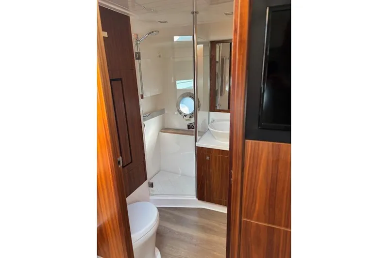 Yacht Photos Pics Luxurious bathroom interior of 2020 Riviera 4800 Sport Yacht with wood accents and modern fixtures.