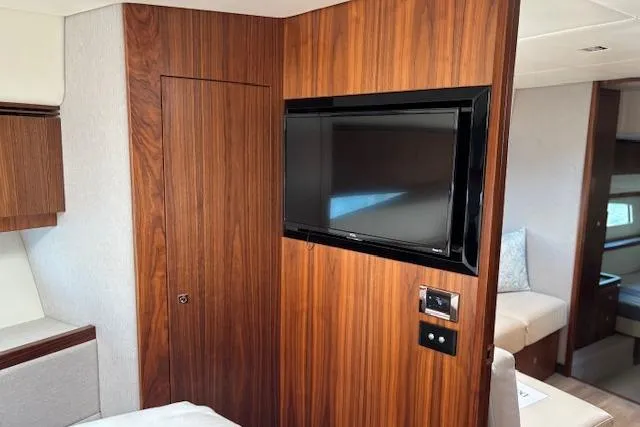  Yacht Photos Pics Interior of 2020 Riviera 4800 Sport Yacht with wood paneling and mounted TV.