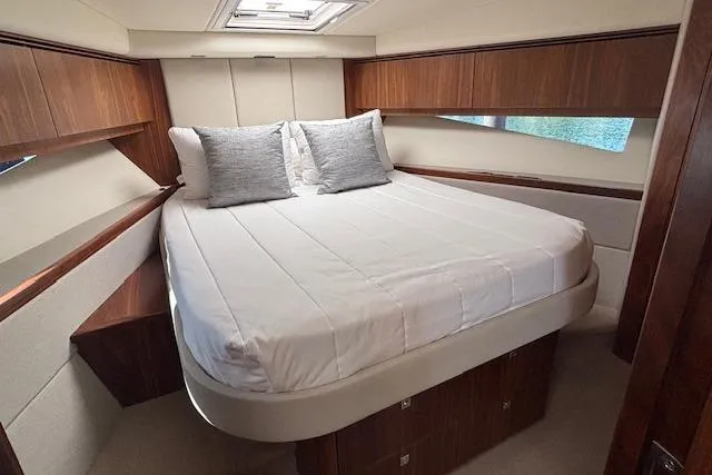  Yacht Photos Pics Luxurious bedroom interior of 2020 Riviera 4800 Sport Yacht with elegant wood finish.