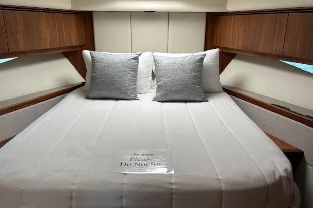  Yacht Photos Pics Luxurious 2020 Riviera 4800 Sport Yacht bedroom with elegant bedding and wooden accents.
