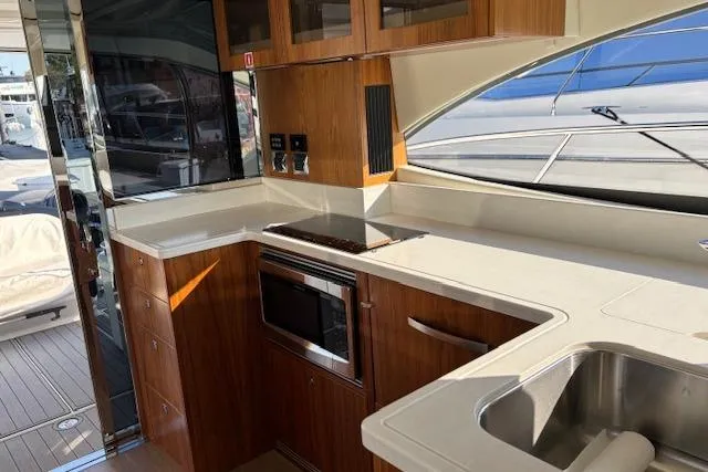  Yacht Photos Pics Modern kitchen interior of 2020 Riviera 4800 Sport Yacht with sleek wood cabinetry.
