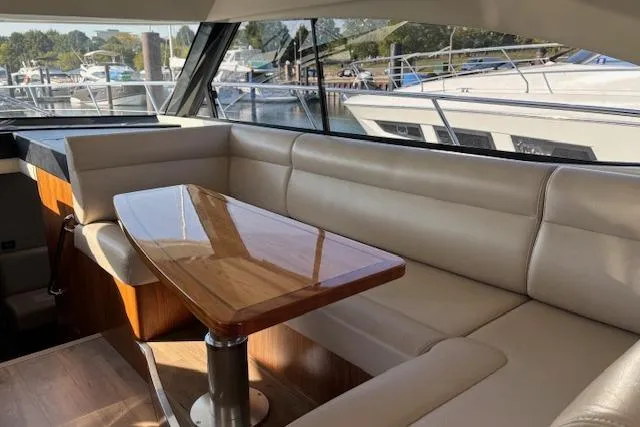  Yacht Photos Pics Interior of 2020 Riviera 4800 Sport Yacht with elegant seating and wooden table.