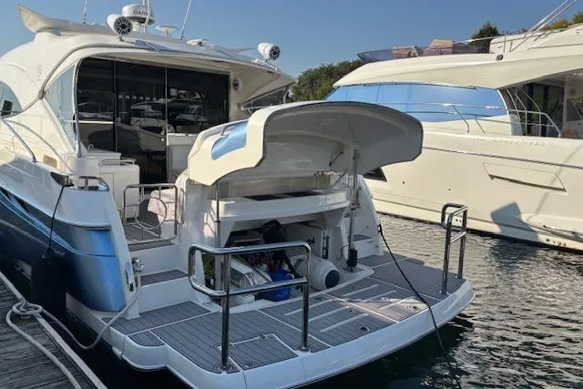  Yacht Photos Pics 2020 Riviera 4800 Sport Yacht docked, showcasing sleek design and spacious deck.