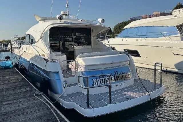  Yacht Photos Pics 2020 Riviera 4800 Sport Yacht docked, rear view, in a marina setting.