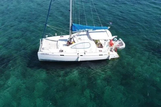 Aerial view of 2008 Leopard 38 catamaran sailing on clear turquoise waters.