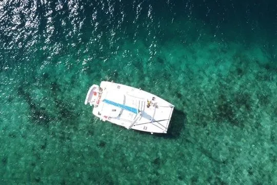 Aerial view of 2008 Leopard 38 catamaran on clear turquoise water.
