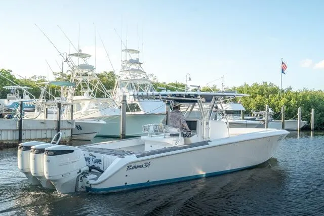  Yacht Photos Pics 2015 Bahama 34 boat docked, featuring triple outboard engines, with other boats in the background.