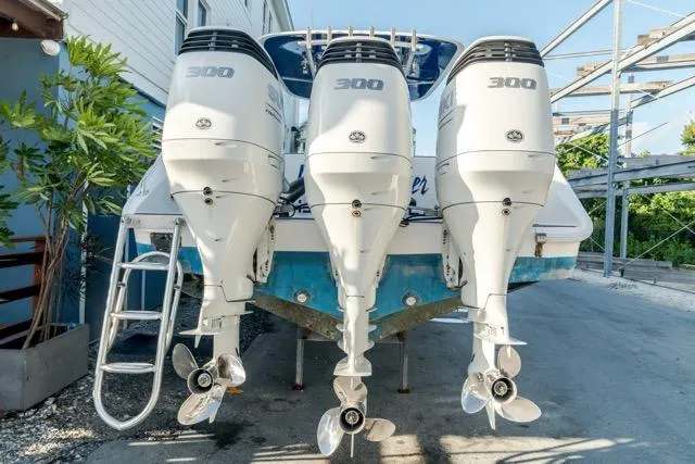  Yacht Photos Pics Triple outboard engines on a 2015 Bahama 34 boat, parked outdoors.