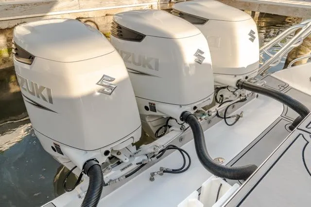  Yacht Photos Pics Triple Suzuki outboard engines on a 2015 Bahama 34 boat, docked in water.