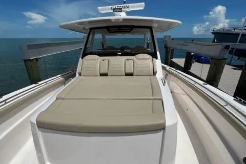  Yacht Photos Pics 2019 Pursuit S408 boat with beige seating, docked by the ocean under a clear blue sky.