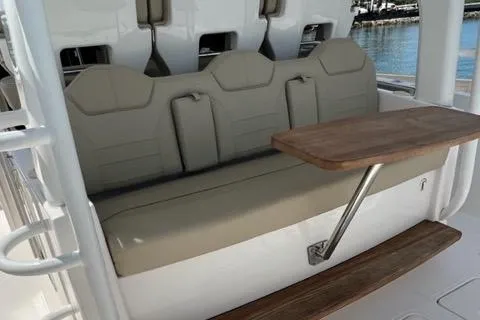  Yacht Photos Pics 2019 Pursuit S408 boat seating with foldable wooden table, docked by the water.
