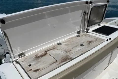  Yacht Photos Pics 2019 Pursuit S408 boat with open storage compartment and weathered surface.