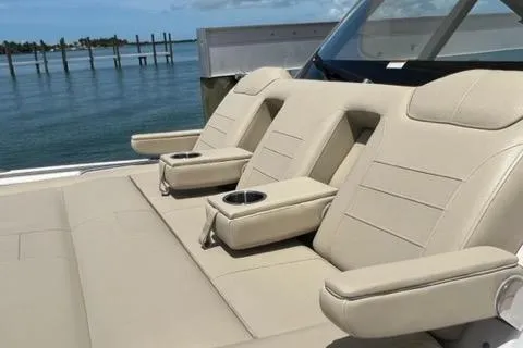  Yacht Photos Pics Luxury seating on 2019 Pursuit S408 boat with cup holders, docked by calm waters.