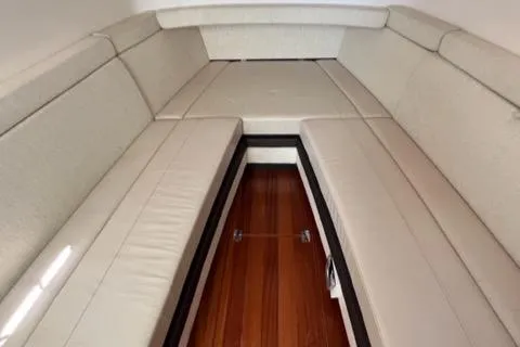  Yacht Photos Pics 2019 Pursuit S408 boat interior with cushioned seating and wooden flooring.