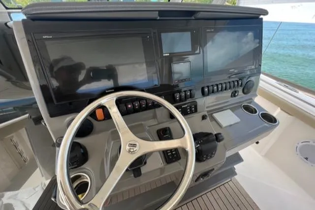  Yacht Photos Pics Control panel of 2019 Pursuit S408 boat with steering wheel and electronic displays.
