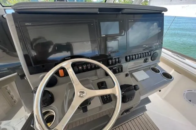  Yacht Photos Pics Control panel of 2019 Pursuit S408 boat with steering wheel and navigation screens.