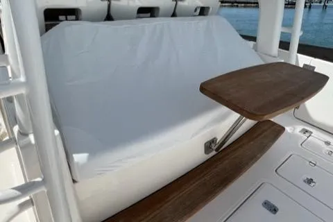  Yacht Photos Pics 2019 Pursuit S408 boat seating area with wooden table and white cover.