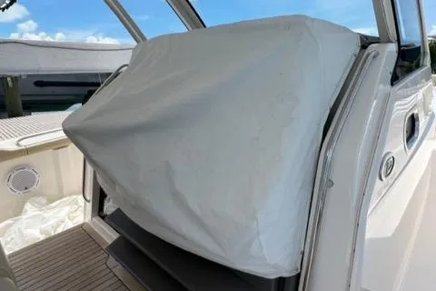  Yacht Photos Pics 2019 Pursuit S408 boat with covered equipment on deck, clear sky background.