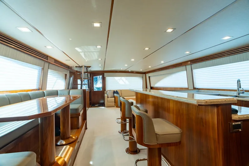 Reel Cents Yacht Photos Pics Luxurious interior of 2019 Viking 80 Enclosed Bridge yacht with elegant seating and wood finishes.