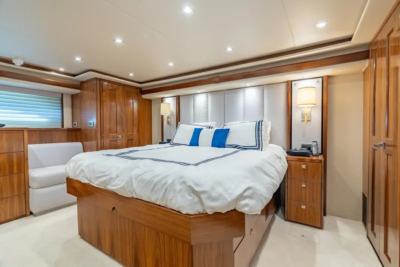 Reel Cents Yacht Photos Pics Luxurious bedroom interior of 2019 Viking 80 Enclosed Bridge yacht with elegant wood finishes.