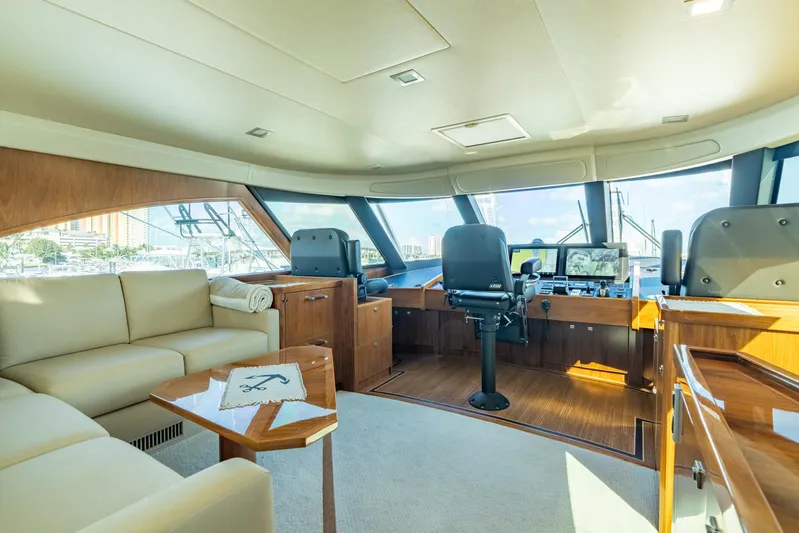 Reel Cents Yacht Photos Pics Luxurious interior of 2019 Viking 80 Enclosed Bridge yacht with helm and seating area.
