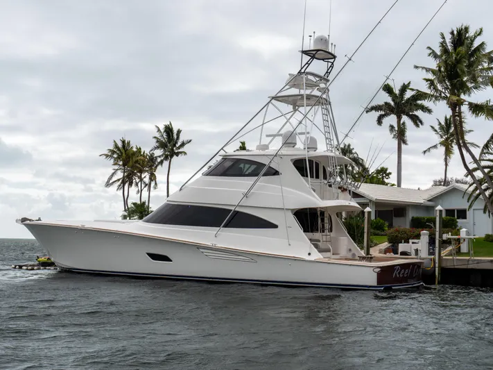 Reel Cents Yacht Photos Pics 2019 Viking 80 Enclosed Bridge yacht docked near palm trees and waterfront home.