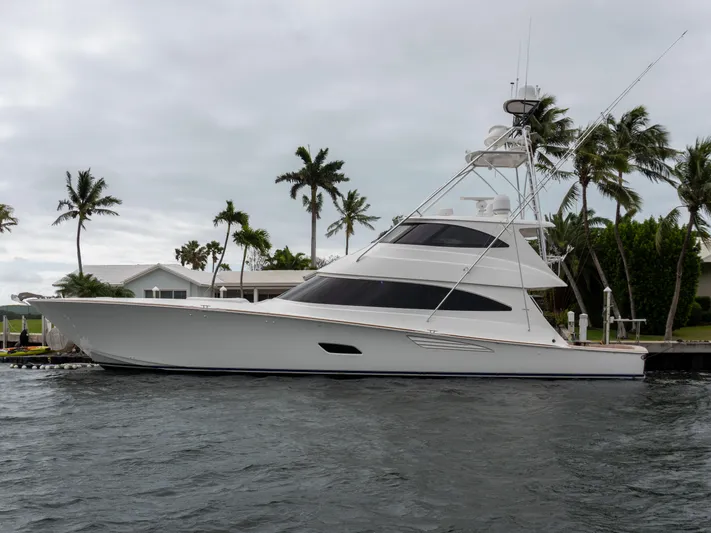 Reel Cents Yacht Photos Pics 2019 Viking 80 Enclosed Bridge yacht docked near palm trees, overcast sky.
