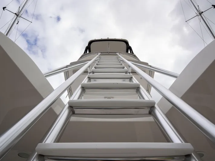 Reel Cents Yacht Photos Pics Ladder view on 2019 Viking 80 Enclosed Bridge yacht against cloudy sky.