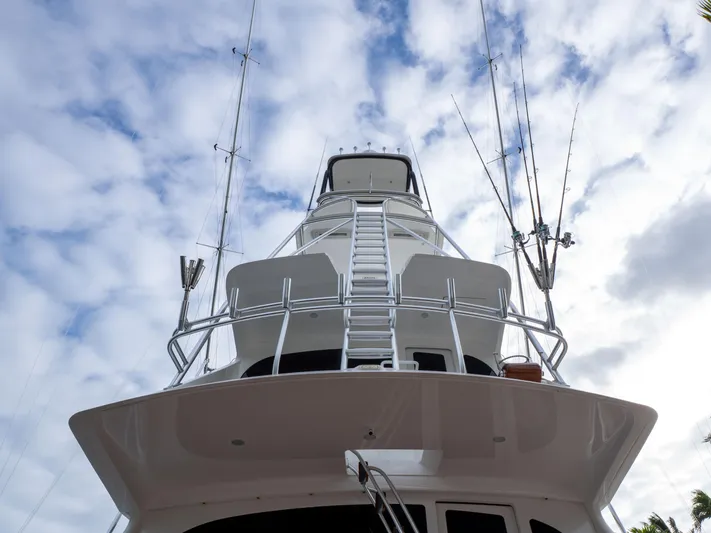 Reel Cents Yacht Photos Pics 2019 Viking 80 Enclosed Bridge yacht, viewed from below against a cloudy sky.