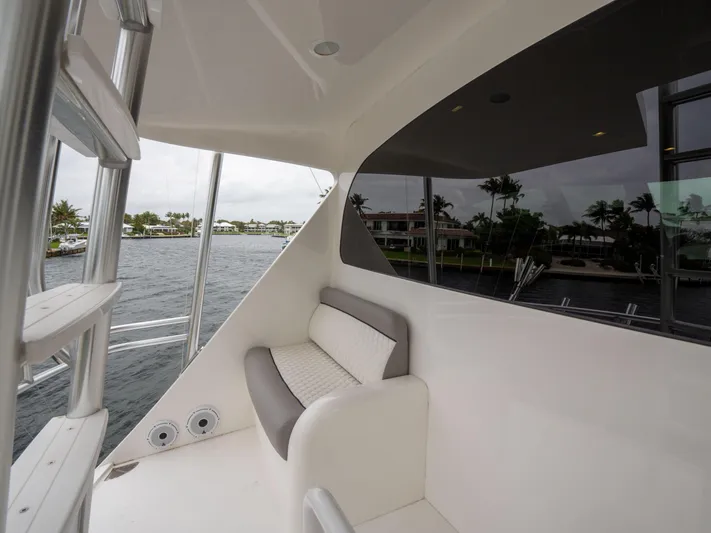 Reel Cents Yacht Photos Pics 2019 Viking 80 Enclosed Bridge yacht with seating area overlooking waterfront.