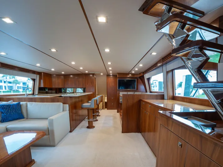 Reel Cents Yacht Photos Pics Luxurious interior of 2019 Viking 80 Enclosed Bridge yacht with modern furnishings and elegant wood finishes.