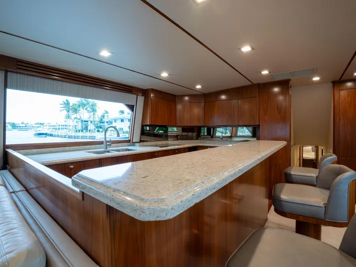 Reel Cents Yacht Photos Pics Luxurious interior of 2019 Viking 80 Enclosed Bridge yacht with modern kitchen design.