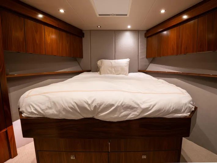 Reel Cents Yacht Photos Pics Luxurious bedroom interior of 2019 Viking 80 Enclosed Bridge yacht with elegant wood finish.