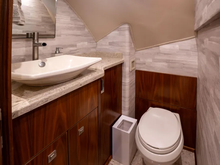 Reel Cents Yacht Photos Pics Luxurious bathroom in 2019 Viking 80 Enclosed Bridge yacht with modern fixtures and wood accents.