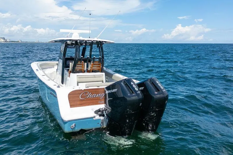 Change Clothes Yacht Photos Pics 2023 Sportsman Open 322 Center Console boat on ocean with twin Mercury engines.