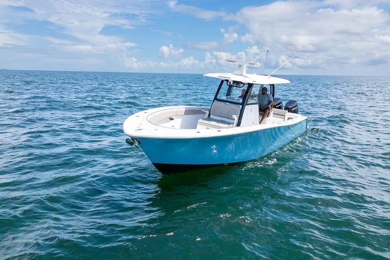 Change Clothes Yacht Photos Pics 2023 Sportsman Open 322 Center Console boat on open sea under blue sky.