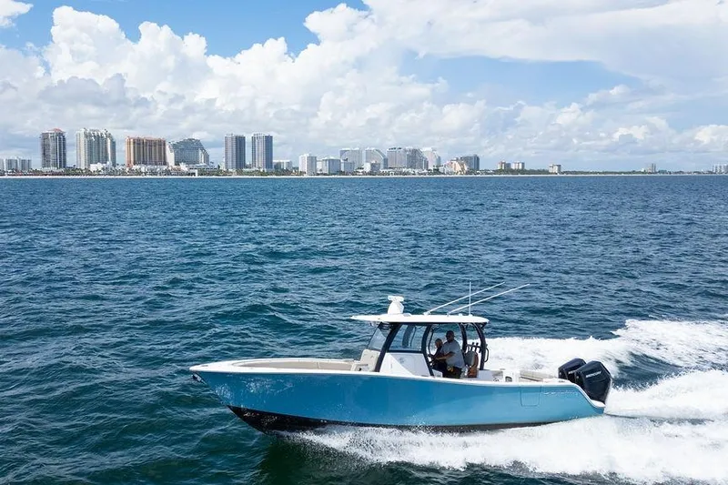 Change Clothes Yacht Photos Pics 2023 Sportsman Open 322 Center Console boat cruising near city skyline.
