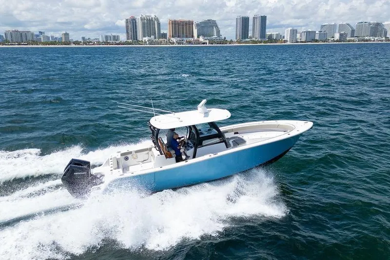 Change Clothes Yacht Photos Pics 2023 Sportsman Open 322 Center Console cruising on ocean near city skyline.